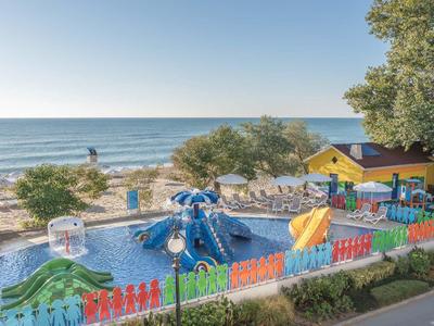 Vue d'une aire de jeux aquatique colorée sur la plage avec la mer en arrière-plan.