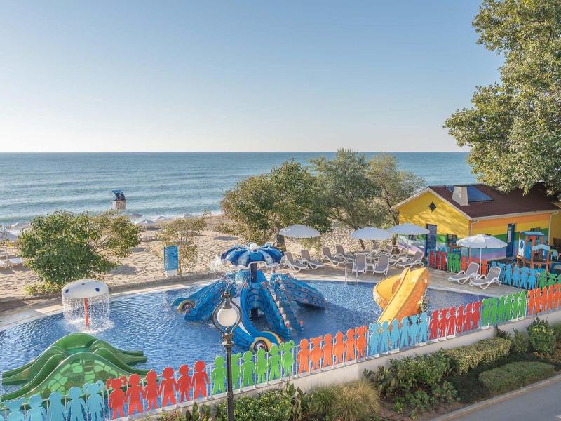 Vue d'une aire de jeux aquatique colorée sur la plage avec la mer en arrière-plan.