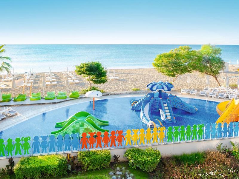 Piscine pour enfants colorée avec animaux gonflables près de la plage avec vue sur la mer.
