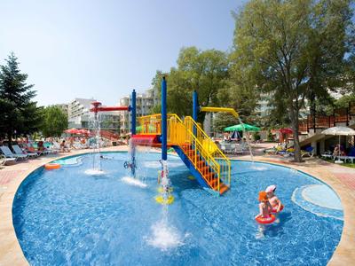 Kinderplanschbecken mit Wasserspielgeräten und Rutsche im Hotelgarten bei Sonnenschein