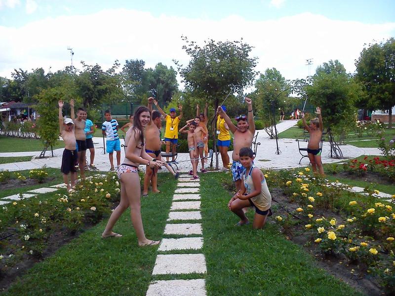 Groepsfoto van mensen in badkleding die poseren op een pad in een tuin.