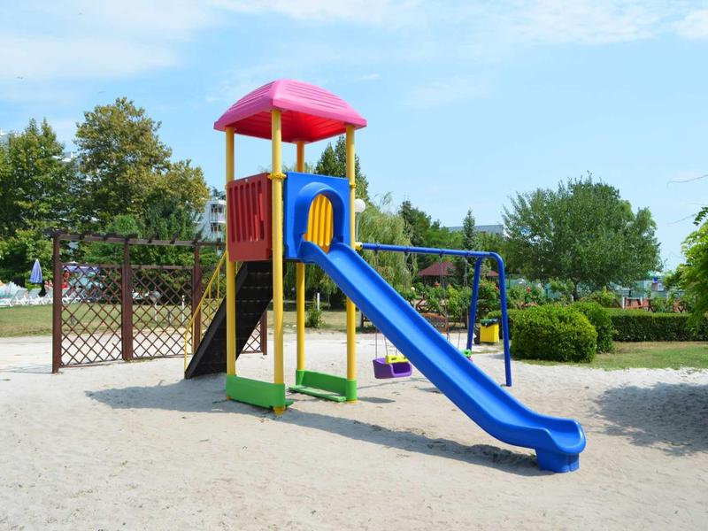 Kleurrijke speeltuin met glijbaan en schommels in een zonnig park.