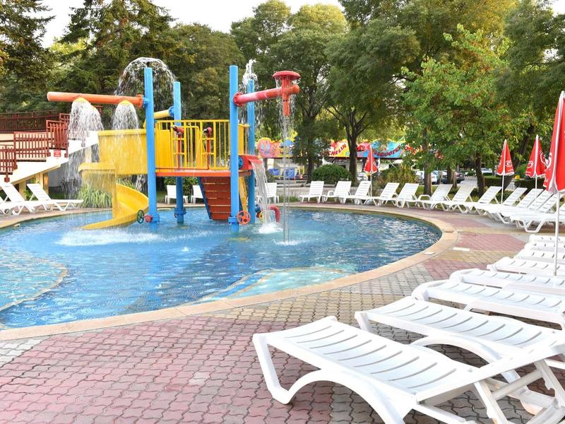 Zwembad met glijbanen en ligstoelen voor gasten bij een hotel