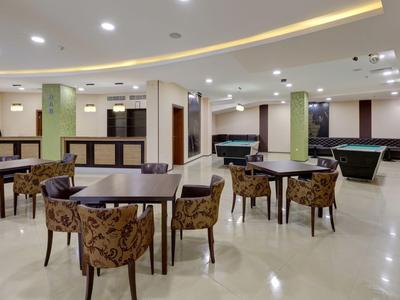 Spacious, bright hotel game room with pool tables and elegant seating.