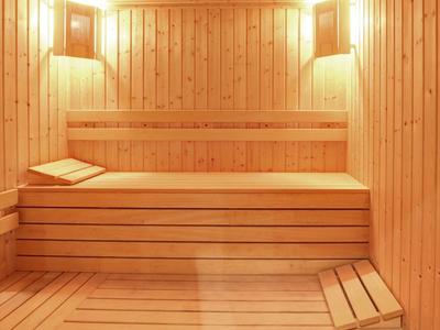 Cozy sauna with wooden benches and warm lighting, perfect for hotel relaxation.