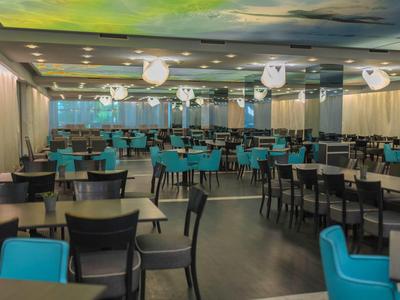 Large modern dining room with many tables and chairs in blue and black.
