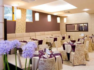 Elegantní jídelna s prostřenými stolky a fialově dekorovanými židlemi v hotelu.