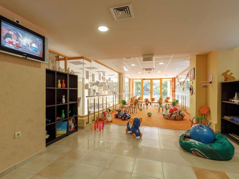 Světle dětský herní prostor s hračkami a posezením v hotelu.