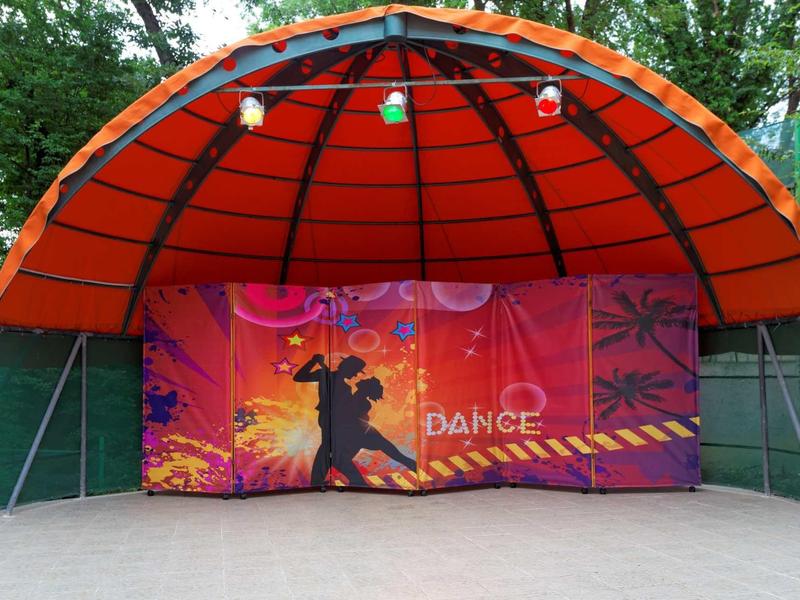 Barevné taneční podium s oranžovo-červenou střechou v parku