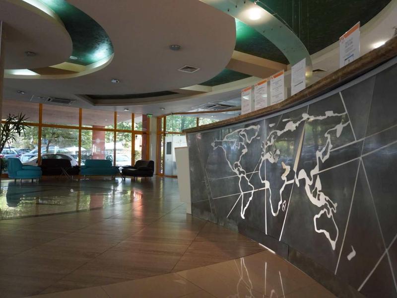 Moderní hotelová lobby s recepčním pultem a velkými okny