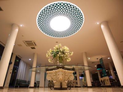 Elegante hall d'hotel con composizione floreale centrale e luce decorativa sul soffitto.