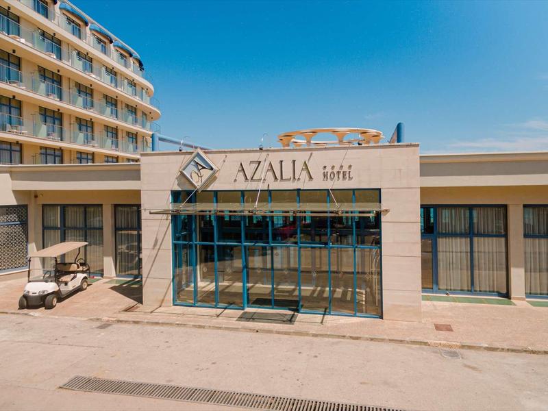 Modernes Hotel Azalia mit großem Glasvorbau und klarem Himmel im Hintergrund.