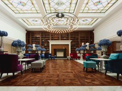 Lussuosa area lounge dell'hotel con lampadari e decorazioni floreali blu.