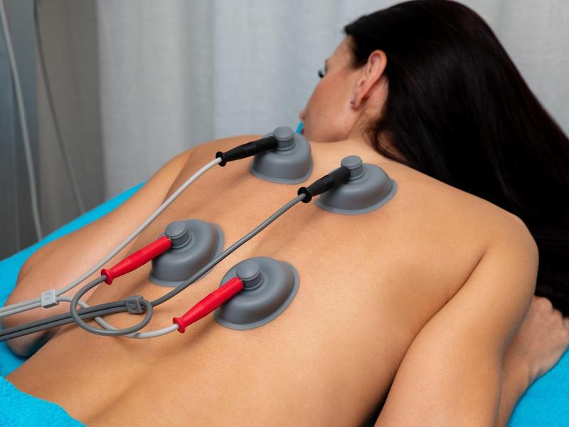 Mujer recibe electroterapia en la espalda en un hotel de bienestar.