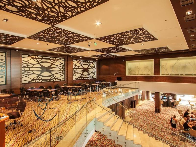 Hall d'hôtel élégant avec boiseries, moquette et plafond décoratif.