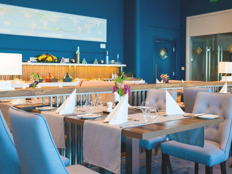 Salle à manger d'hôtel moderne avec intérieur bleu et tables dressées.
