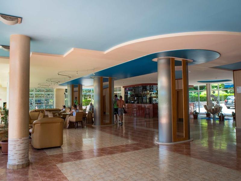 Großer offener Empfangsbereich mit Säulen, Sitzgruppen und hellblauem Deckendesign.