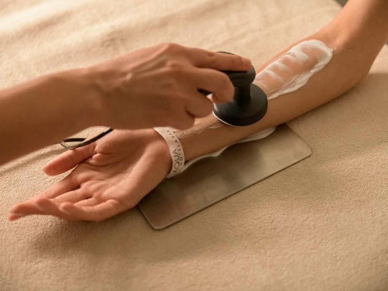 A person receives laser treatment on the forearm for skin care.