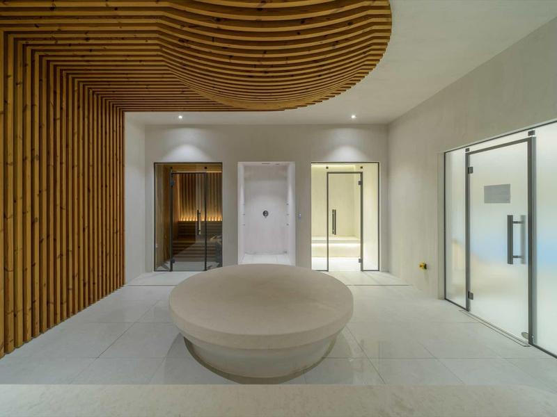 Modern hotel lobby with curved wooden ceiling and round seating.