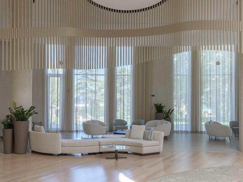 Bright, modern hotel lobby area with curved sofa and large windows