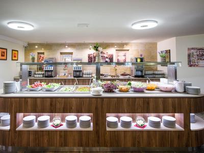 Buffet mit Frühstücksangebot in einem hellen, modernen Speiseraum eines Hotels.