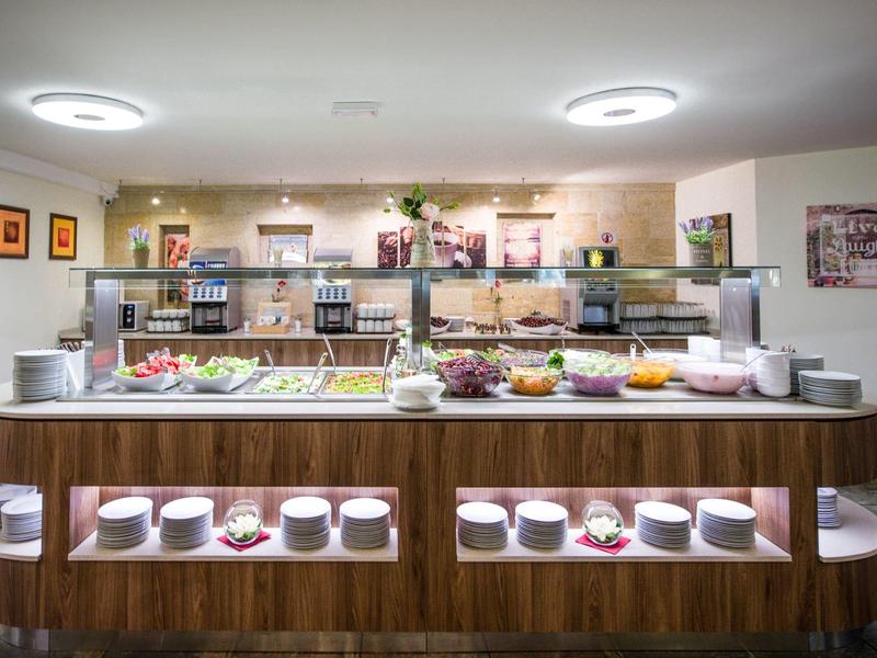 Buffet mit Frühstücksangebot in einem hellen, modernen Speiseraum eines Hotels.