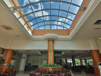 Duża przestrzeń wewnętrzna z szklanym dachem i miejscami do siedzenia w hotelu.