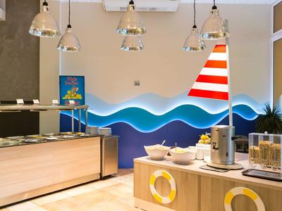 Moderní hotelová snídaňová část s bufetem a námořnickou dekorací na stěně