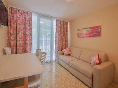 Przytulny pokój hotelowy z sofą, stołem i kolorowymi zasłonami.