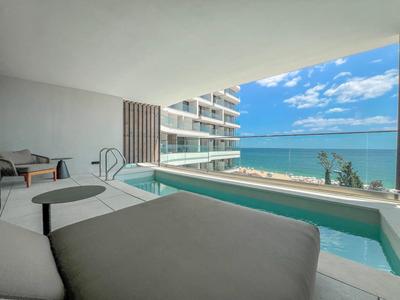 Nowoczesny balkon z basenem i widokiem na morze w pokoju hotelowym.