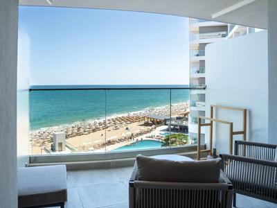 Balkon z meblami i widokiem na basen oraz plażę nad morzem