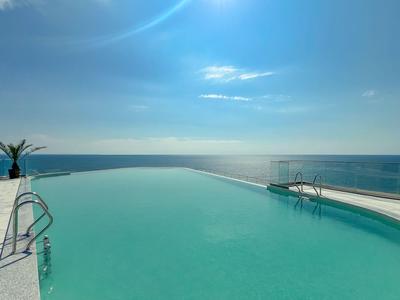 Infinity pool with sea view under clear blue sky