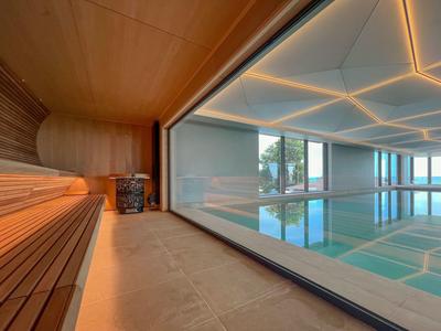 Nowoczesny kryty basen z sauną i dużym oknem do relaksu