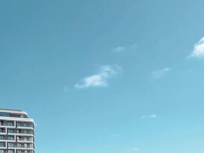 Nowoczesny hotel blisko plaży pod jasnym niebem.