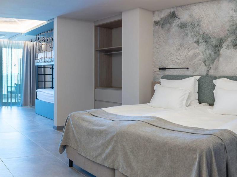 Nowoczesny pokój hotelowy z dużym łóżkiem, biurkiem i balkonem z widokiem na zewnątrz.