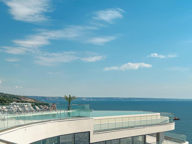 Taras na dachu z przeszklonym balustradą i widokiem na morze przy czystym niebie