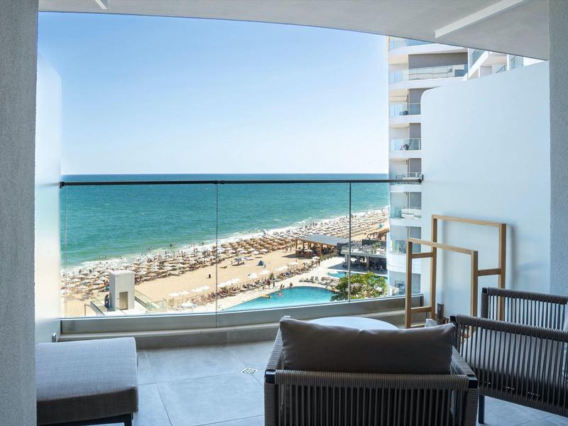 Balkon z meblami i widokiem na basen oraz plażę nad morzem