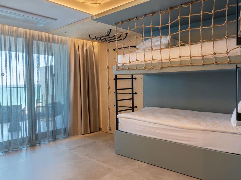 Pokój z łóżkiem piętrowym i balkonem z widokiem na morze w hotelu