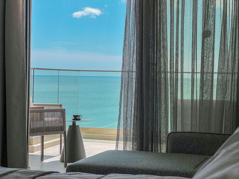 Widok z pokoju hotelowego na balkon z widokiem na morze i nowoczesne meble.