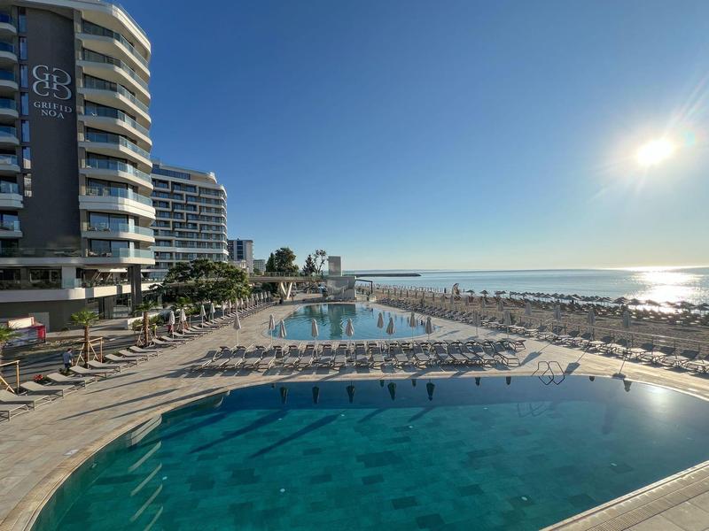 Basen hotelowy z leżakami nad morzem pod czystym niebem i jasnym słońcem