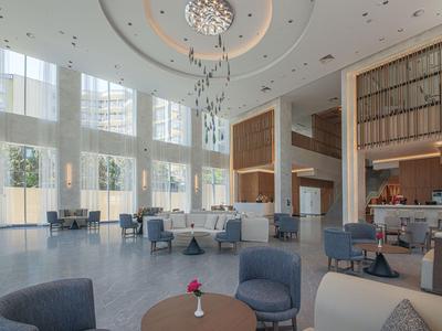 Prostorná hotelová hala s moderním posezením a lustry.