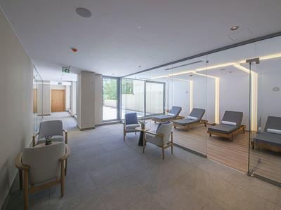 Moderner Ruheraum mit Liegestühlen, Stühlen und großen Fenstern für viel Tageslicht.