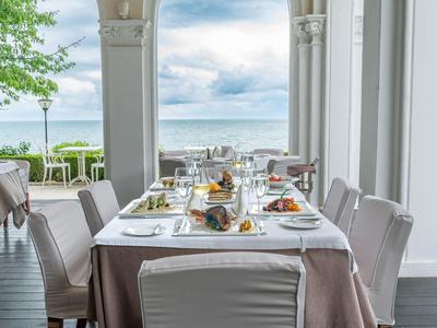 Tavolo elegantemente apparecchiato con vista sul mare in un ristorante dell'hotel.