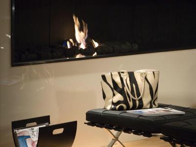 Nowoczesny pokój z otwartym kominkiem, stylową częścią wypoczynkową i minimalistycznym designem.