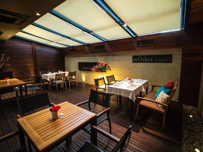 Przytulna restauracja z drewnianymi stołami, krzesłami i jasnym światłem z szklanego dachu.