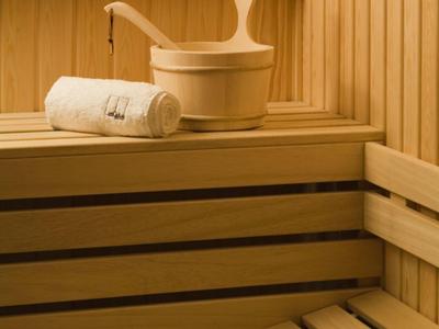 Nowoczesny pokój hotelowy z otwartą łazienką i czerwonym narzutem na łóżko.