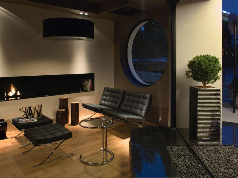 Przytulny salon z kominkiem, nowoczesnymi meblami, roślinami i regulowanym oświetleniem.