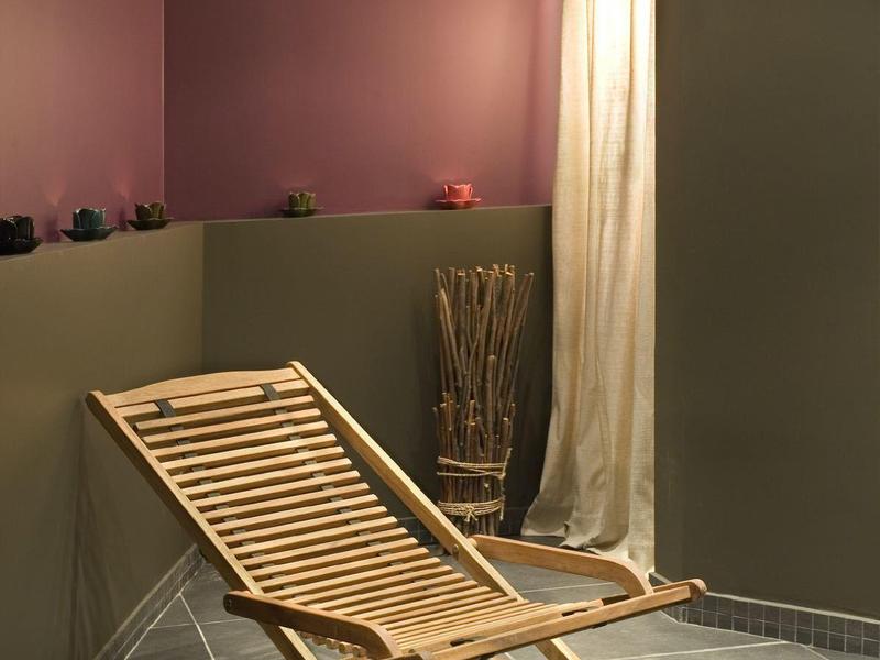 Nowoczesny drewniany leżak w spokojnej, minimalistycznej przestrzeni wewnętrznej z dużymi płytkami.