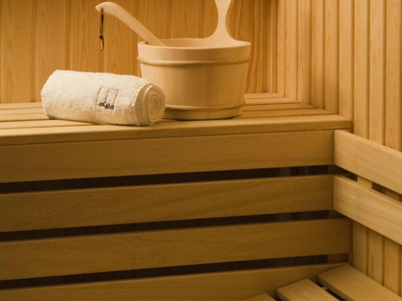 Nowoczesny pokój hotelowy z otwartą łazienką i czerwonym narzutem na łóżko.