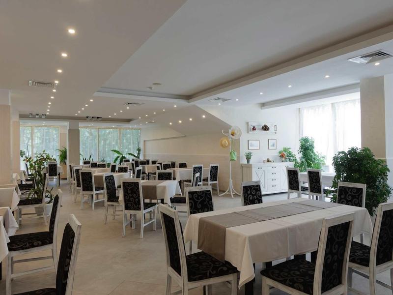 Bright restaurant with set tables and black chairs in a modern design.